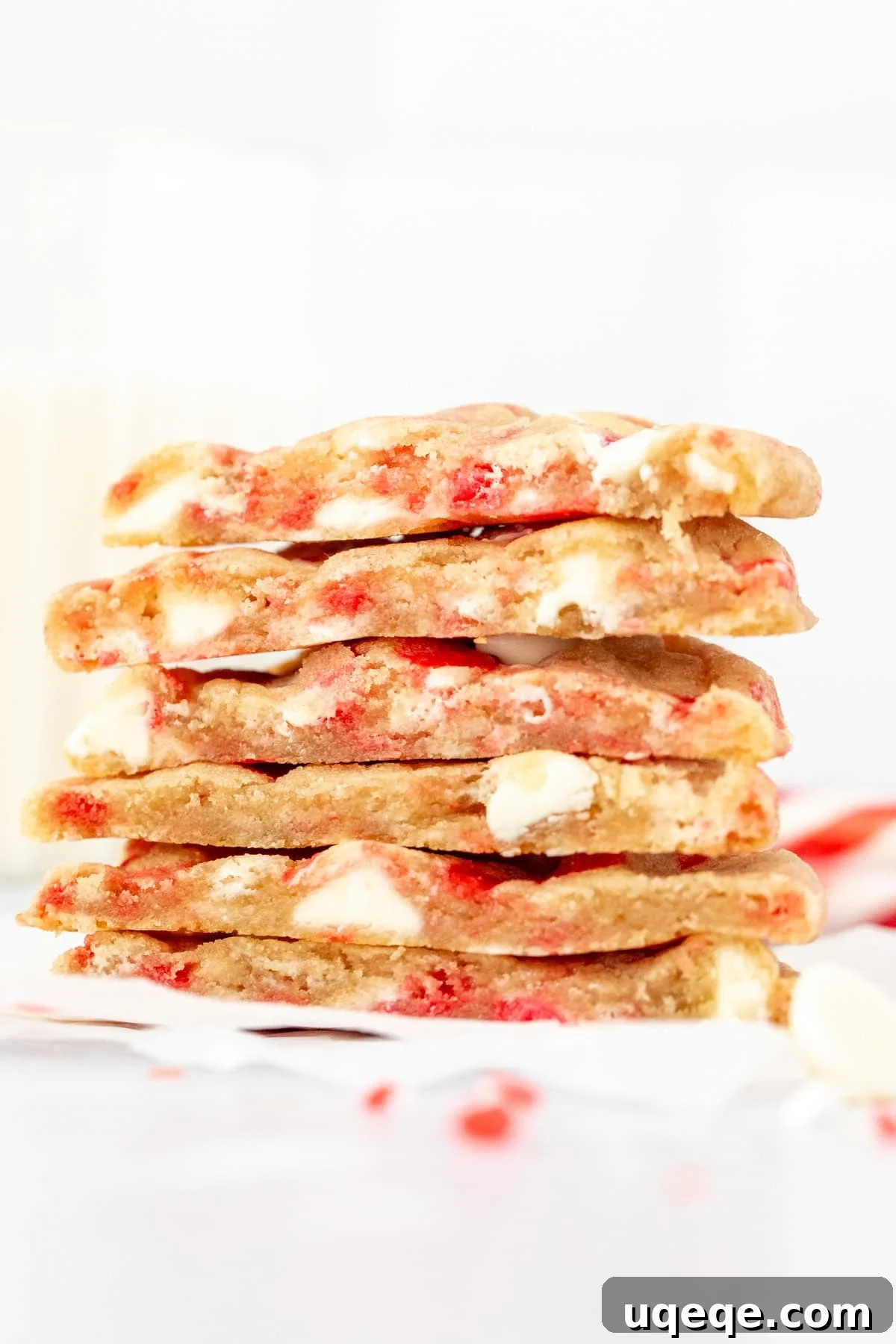 Peppermint Swirl White Chocolate Delights 6 Close-up of white chocolate chip candy cane cookies, one cut in half to show the soft interior, stacked