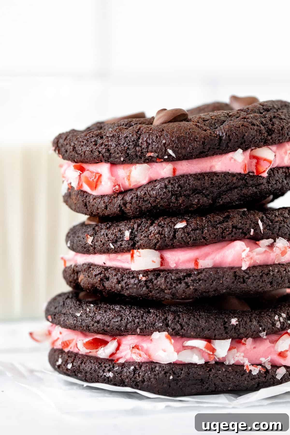 Rich Chocolate Peppermint Creme Cookies 4 Three chocolate peppermint sandwich cookies with delicate pink frosting, stacked beautifully.