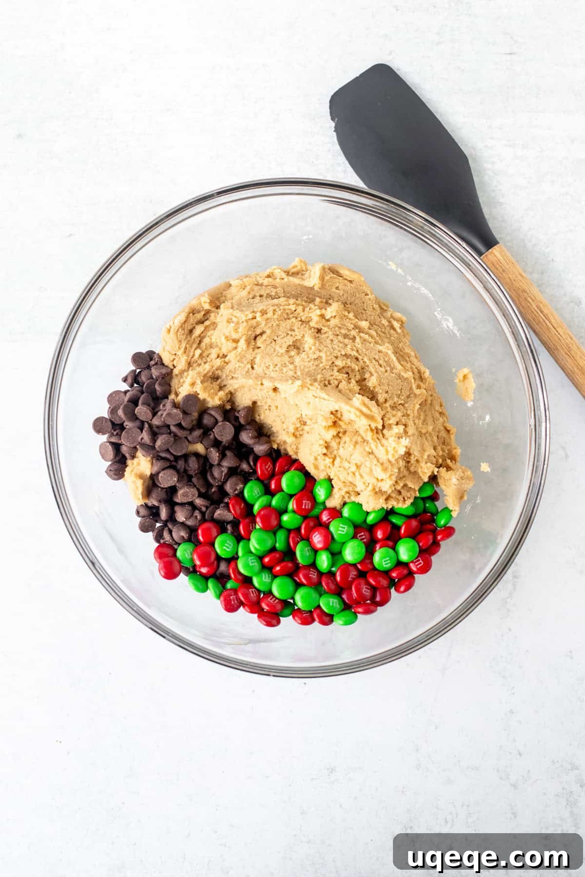 Festive M&M Delights 4 Bowl of cookie dough with vibrant red and green M&Ms ready to be mixed in for festive Christmas cookies.