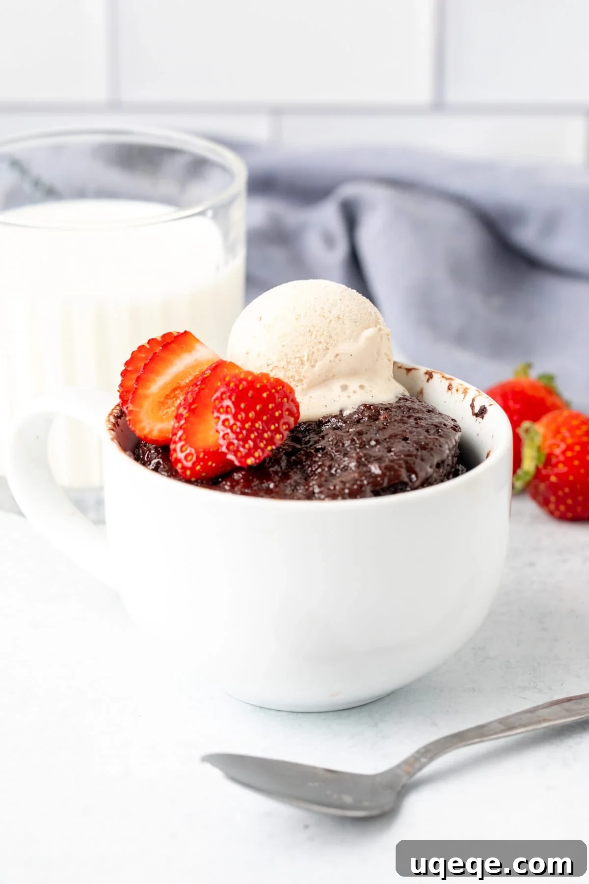 Decadent Nutella Mug Cake 6 Single serving Nutella cake in a mug, topped with ice cream and mixed berries, served alongside a glass of milk