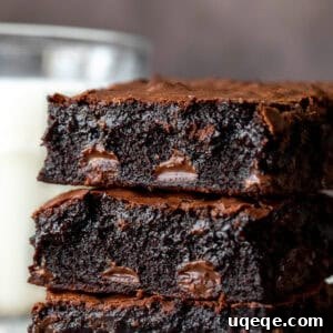 Stack of three chocolate chip brownies with glass of milk