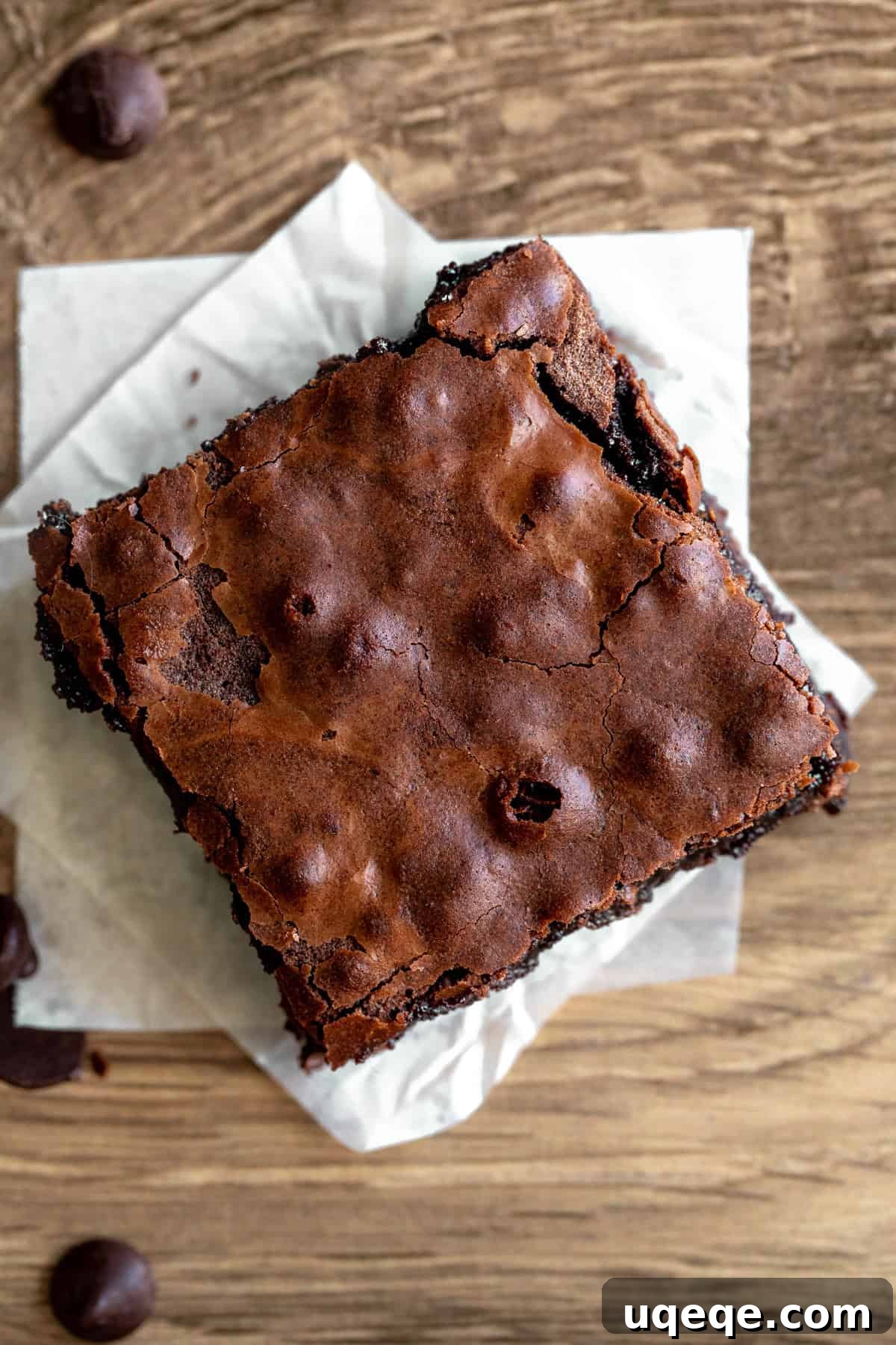 Perfectly Chewy Fudgy Homemade Brownies with Rich Cocoa 8 Brownie with crinkly top on a square of parchment paper, ready to be cut