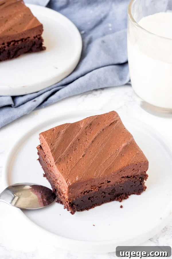 Ultimate Brownie Finish 5 A delicious brownie topped with rich chocolate brownie frosting, accompanied by a refreshing glass of milk, highlighting the perfect pairing.