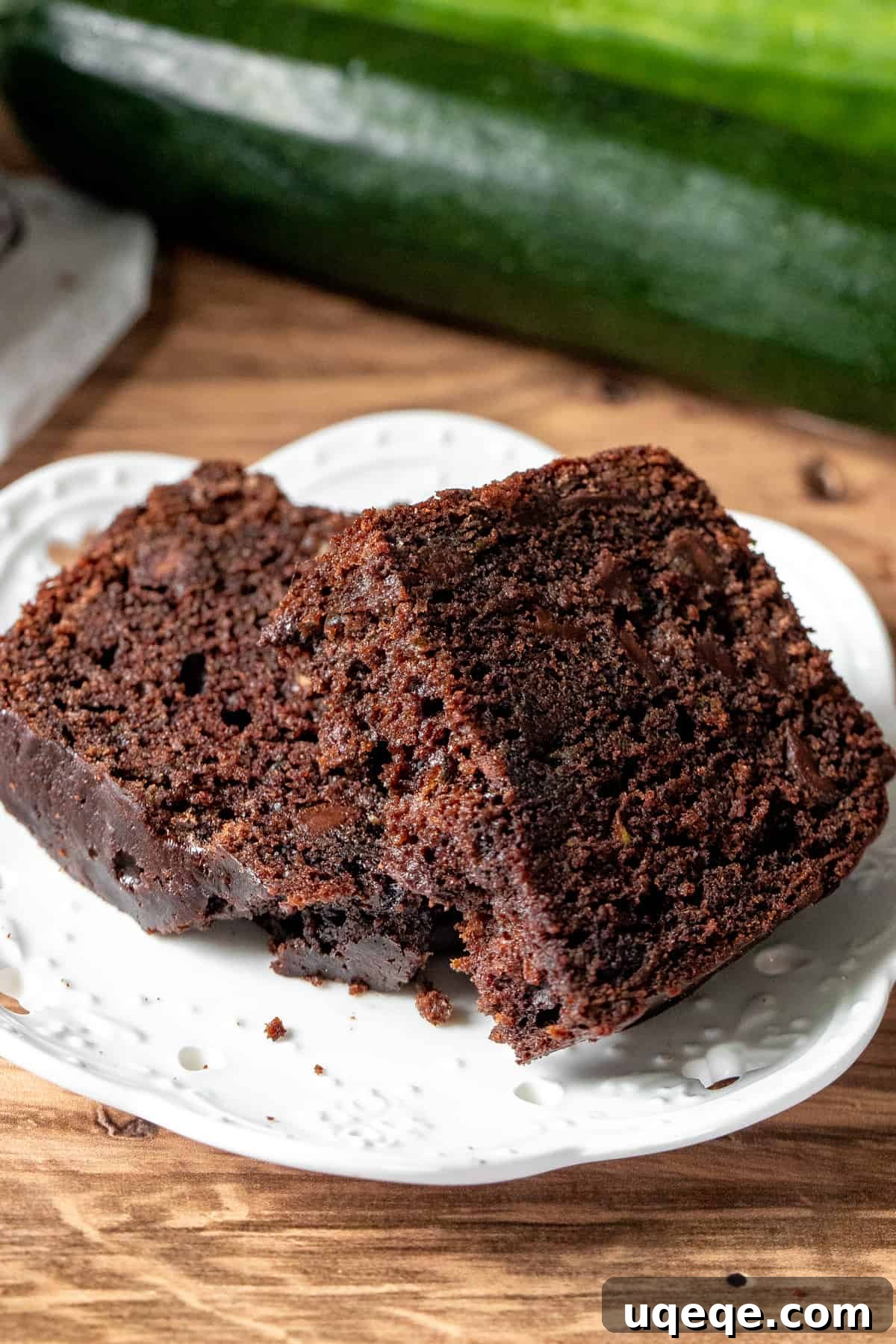 Decadent Chocolate Zucchini Loaf 7 A slice of chocolate zucchini loaf broken in half on a plate, highlighting its tender, moist interior