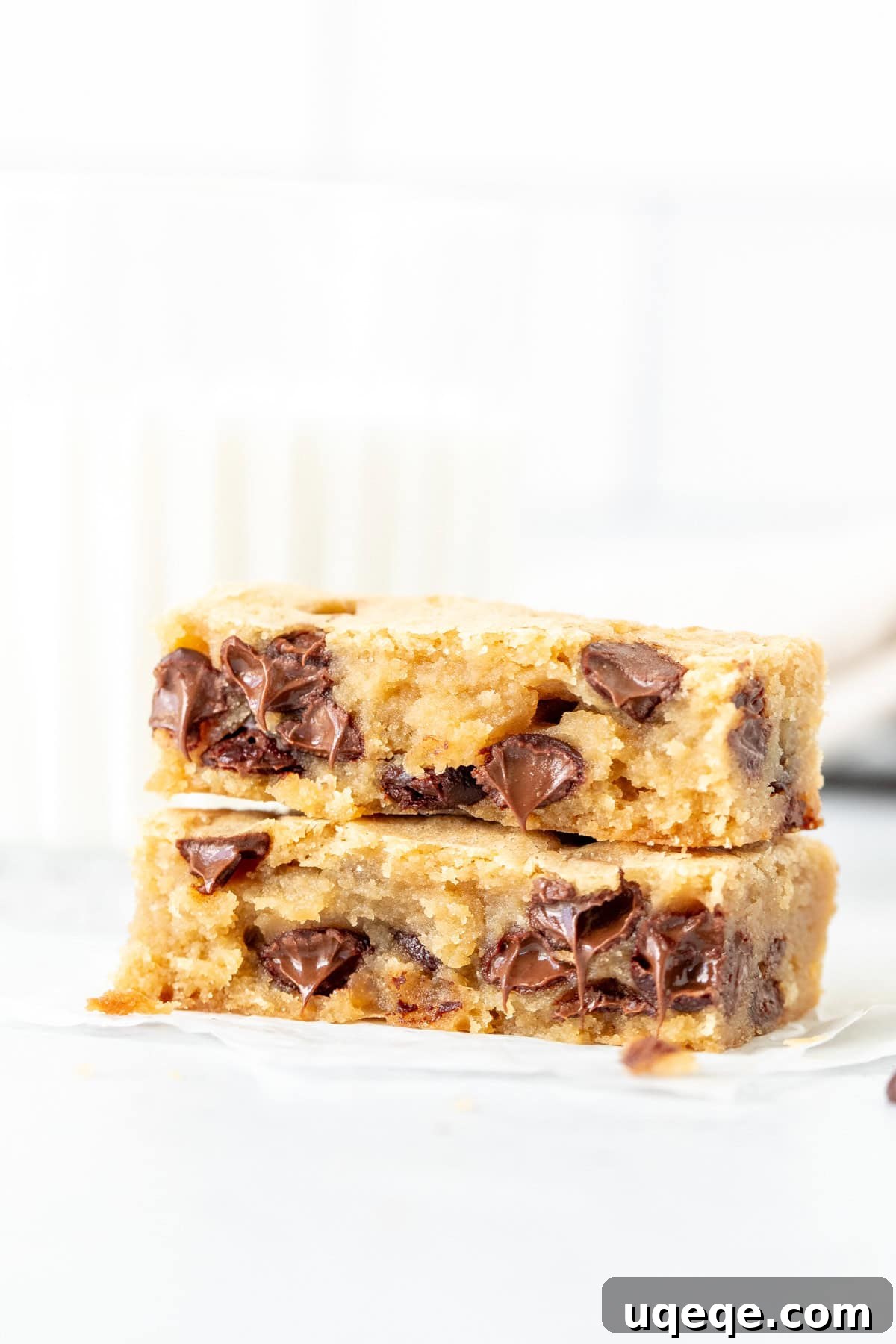 Blondie Bliss 6 Close-up of a chocolate chip blondie broken in half, showing its chewy and gooey interior.