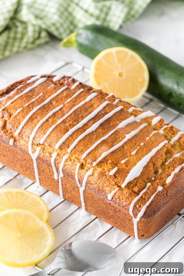 Zesty Lemon Zucchini Loaf 3 Freshly baked lemon zucchini bread cooling on a wire rack, beautifully drizzled with a bright, homemade lemon glaze, signaling its readiness to be enjoyed.