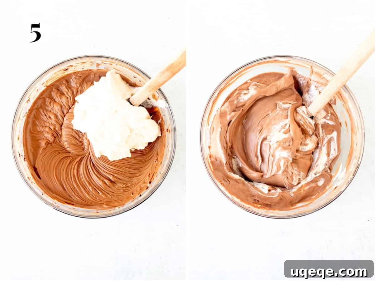 Decadent No Bake Chocolate Cheesecake 7 A bowl displaying the rich no-bake chocolate cheesecake batter, with a rubber spatula gently folding in the last of the white whipped cream, aiming for a perfectly even consistency.