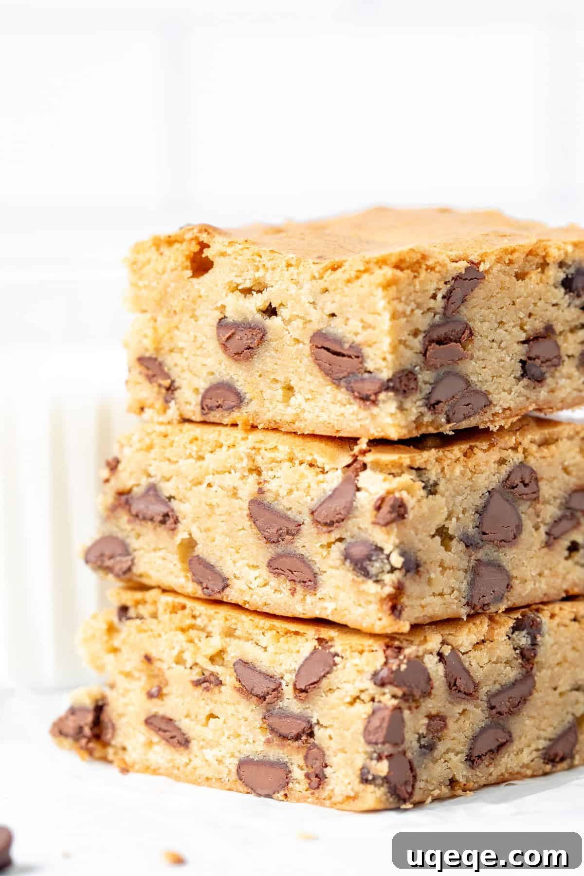 Ultimate Chewy Chocolate Chip Bars 2 A stack of three soft and chewy chocolate chip cookie bars, showcasing their golden-brown edges and abundance of melted chocolate chips.