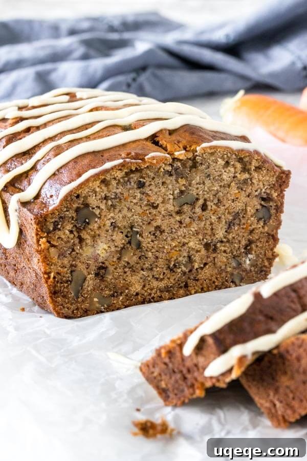 Sliced banana carrot bread showing its moist crumb, grated carrots, and chopped walnuts, ready to be enjoyed.