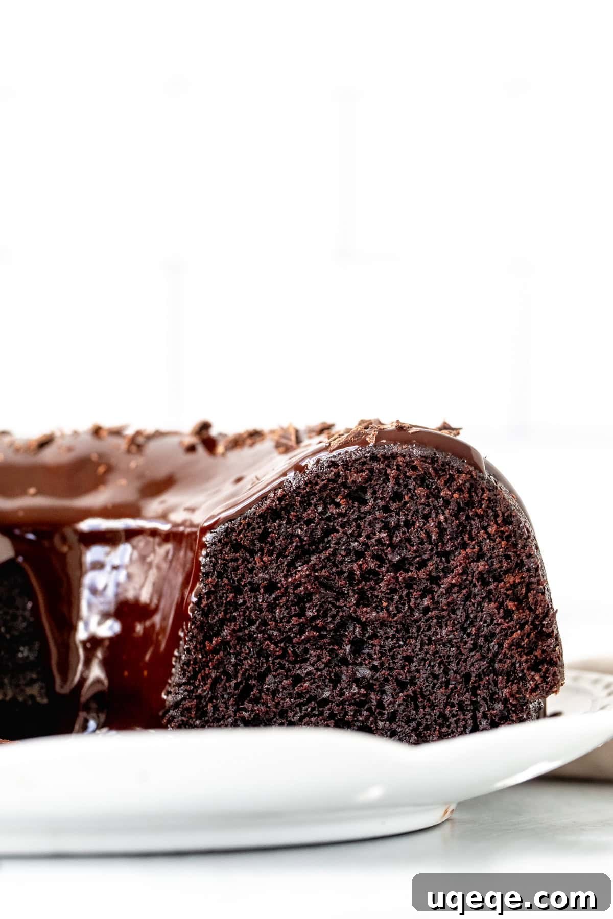 Decadent Chocolate Bundt Delight 3 A decadent slice of chocolate bundt cake, showcasing its moist, fudgy interior and the generous drip of chocolate ganache.