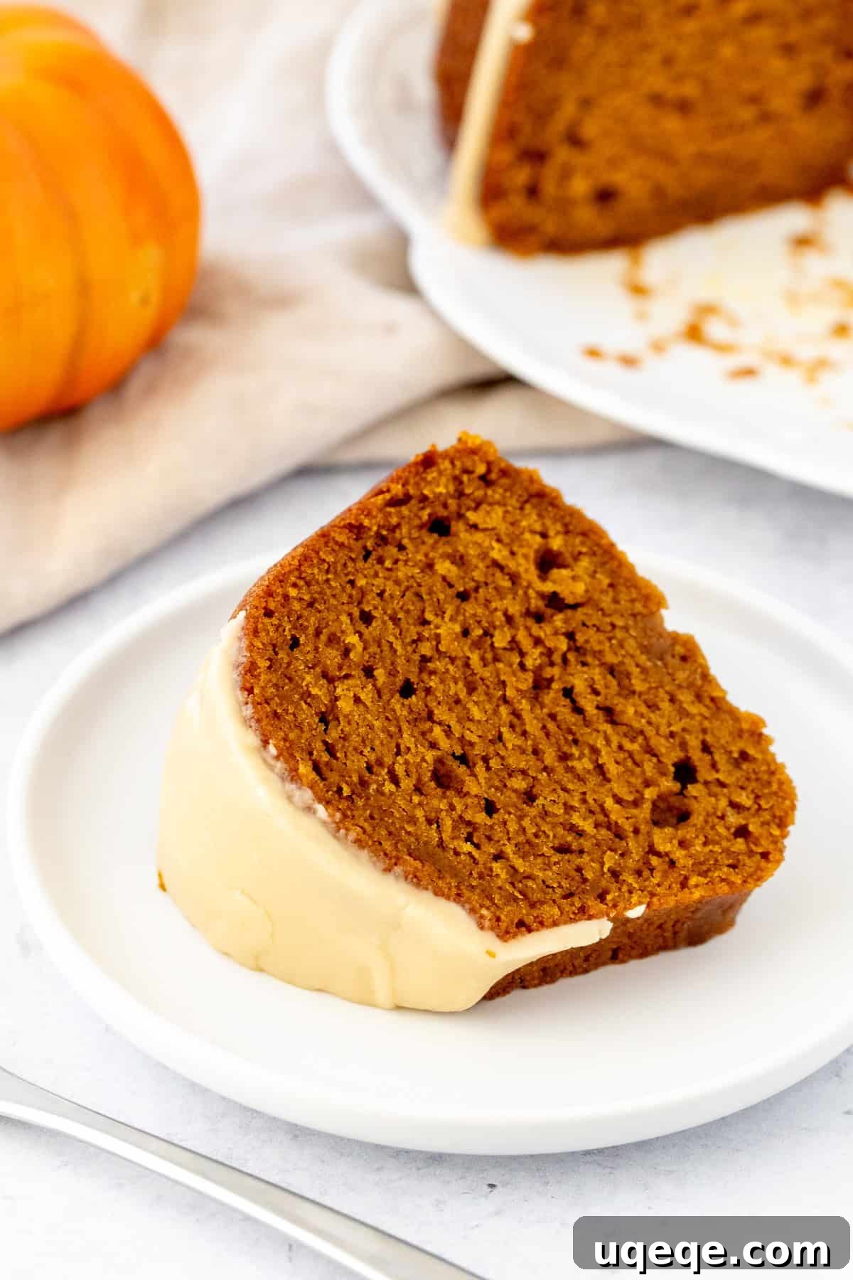 Spiced Pumpkin Bundt Delight 8 A close-up slice of moist pumpkin bundt cake with maple glaze, showing the tender crumb