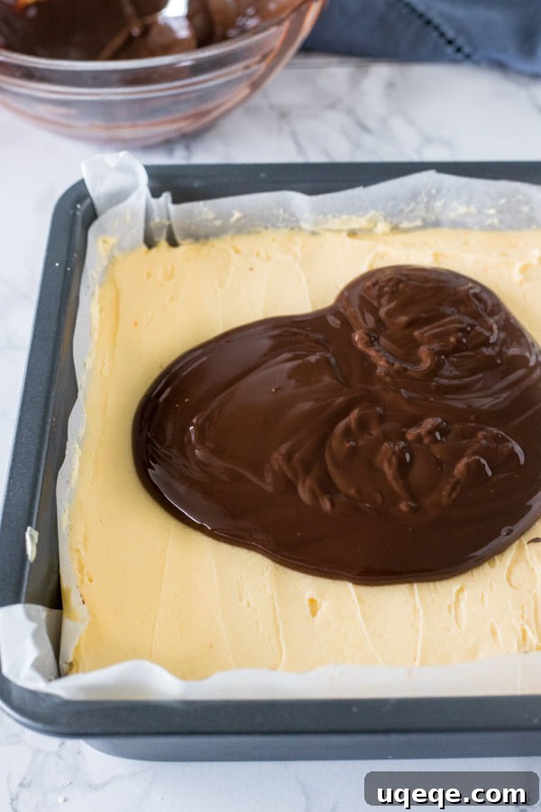 Triple Layer Nanaimo Bliss 6 How to make Nanaimo Bars: melted chocolate topping poured over the custard buttercream layer, ready to be spread smooth.