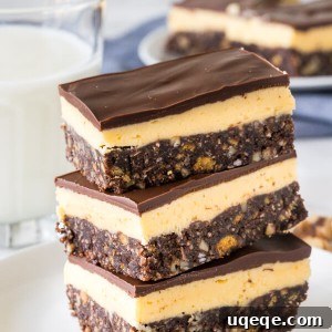 A stack of 3 classic Nanaimo bars on a white plate with a glass of milk in the background, ready to be enjoyed.