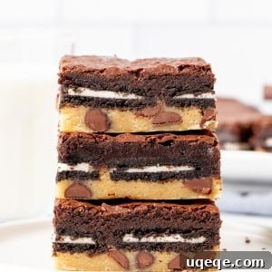 Stack of three ultimate layered brownies on a plate