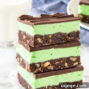 A stack of 3 mint Nanaimo bars shot from the side to see the 3 layers.