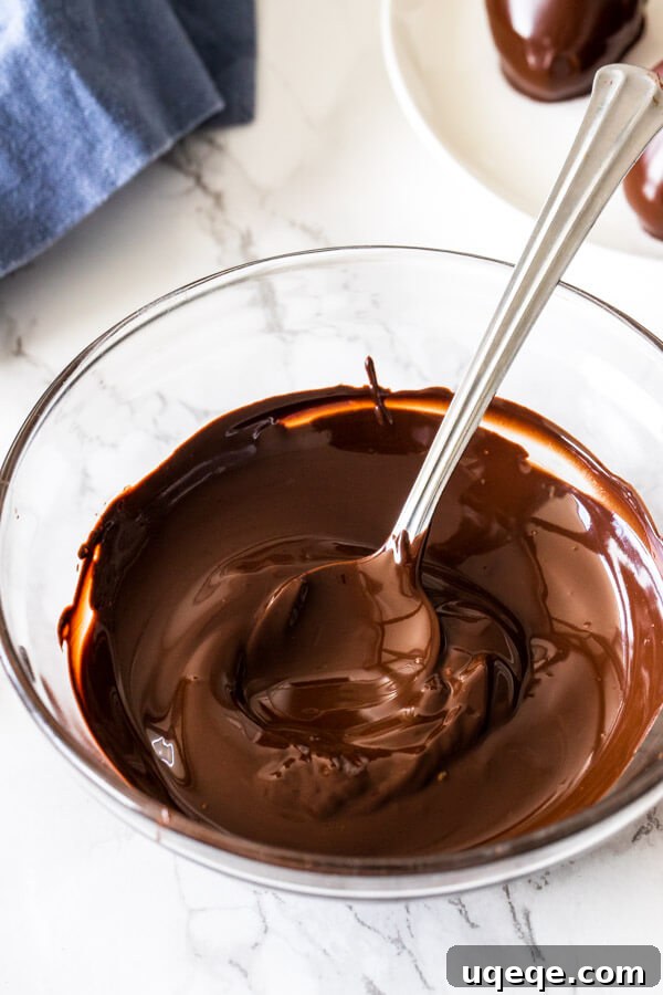 Mastering Chocolate Melting 5 A perfectly melted, smooth, and glossy pool of chocolate rests in a clear glass bowl, ready for any culinary application.
