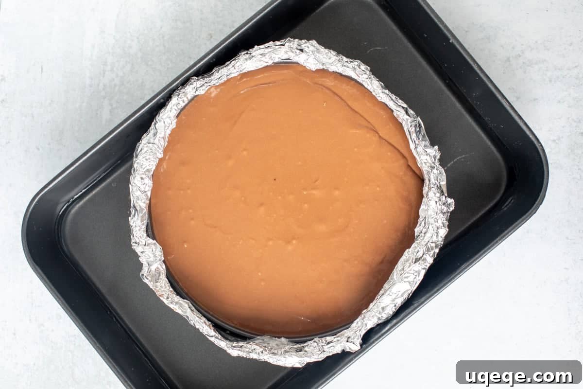 Decadent Nutella Oreo Cheesecake 7 Springform pan of unbaked Nutella cheesecake in a large roasting pan
