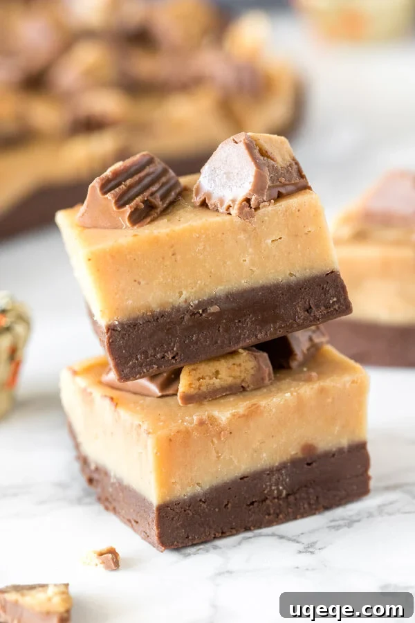 Chocolate Peanut Butter Buckeye Fudge 2 Two pieces of layered chocolate peanut butter fudge stacked on top of each other, showcasing the distinct layers of chocolate and peanut butter fudge