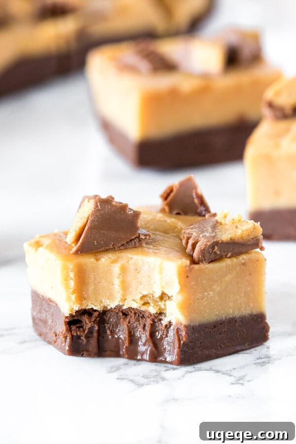 Chocolate Peanut Butter Buckeye Fudge 4 A piece of layered peanut butter chocolate fudge with a bite taken out of it, showing the creamy texture and distinct layers.