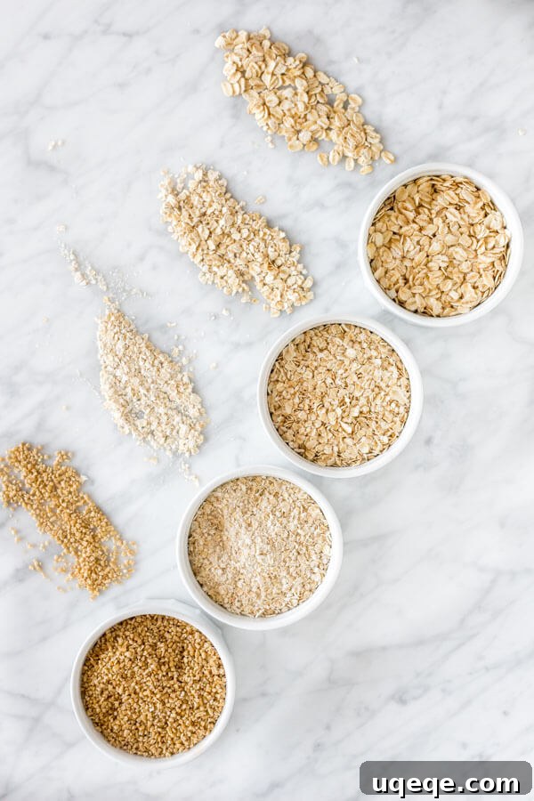 A visual comparison of old-fashioned, quick, instant, and steel-cut oats arranged top to bottom on a polished marble surface, illustrating their varying sizes and textures.
