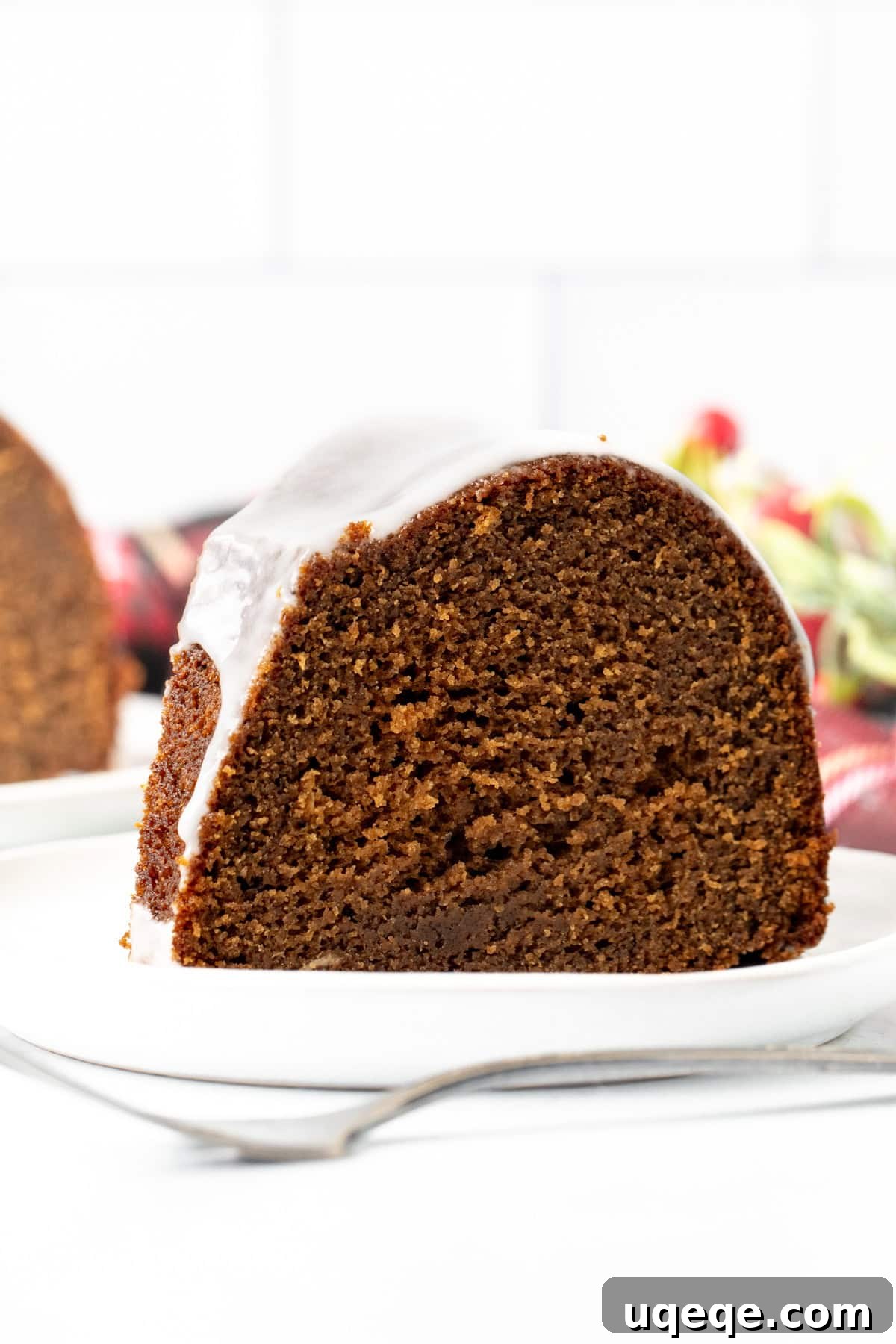 Molasses Spiced Bundt Bliss 2 Slice of gingerbread bundt cake on a plate, showing its moist texture and glistening lemon glaze, ready to be enjoyed.