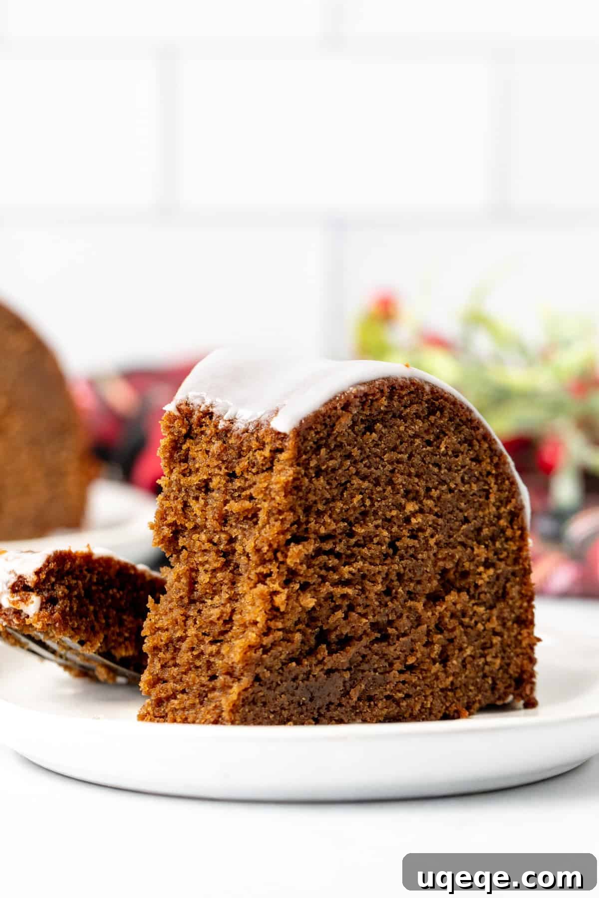 Molasses Spiced Bundt Bliss 10 Close-up of a perfectly sliced gingerbread bundt cake with lemon glaze, revealing its tender, moist interior, with a tempting bite taken out.
