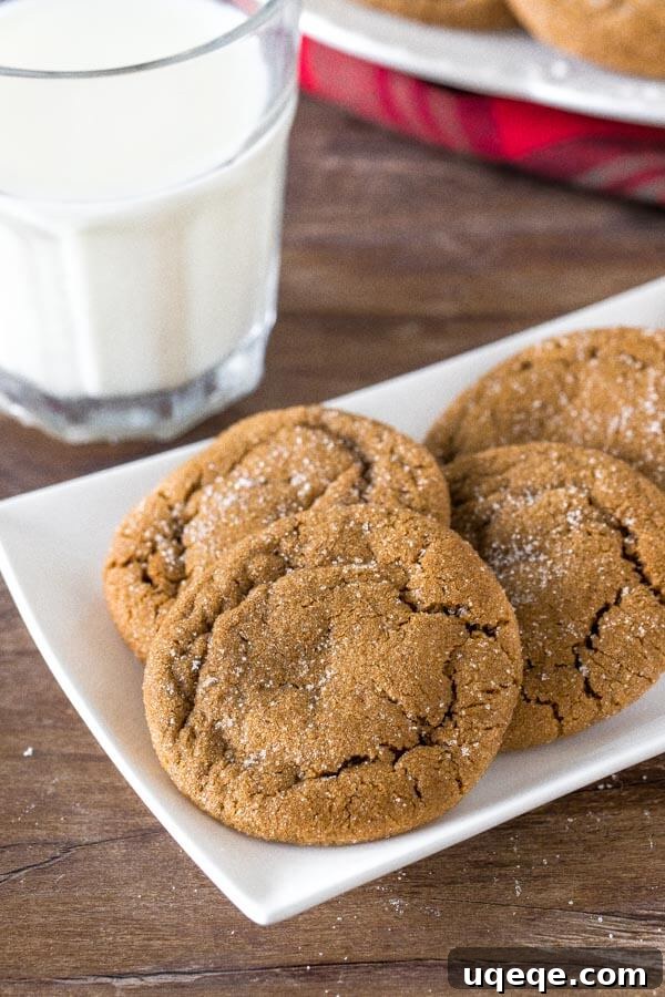 Irresistibly Soft and Chewy Ginger Molasses Cookies 2 A plate of soft, chewy ginger molasses cookies rolled in sugar with a glass of milk, invitingly arranged for a cozy treat