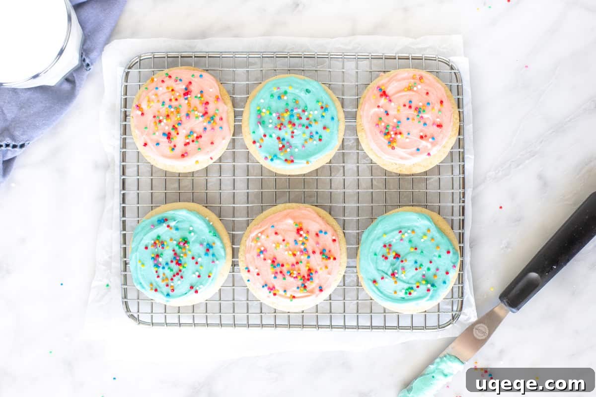 Pillowy Soft Sour Cream Sugar Cookies 3 6 frosted sugar cookies on a cooling rack