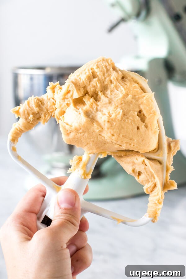 Paddle attachment of mixer with caramel frosting.