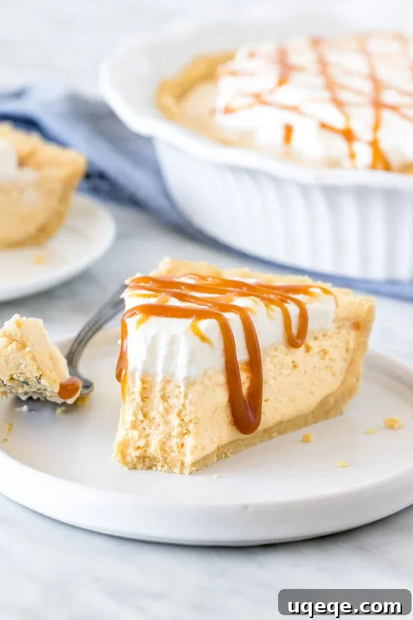 Golden Caramel Bliss Pie 4 A delectable slice of no-bake caramel cream pie, with a perfect bite taken out, revealing the creamy filling and crunchy crust on a white plate.