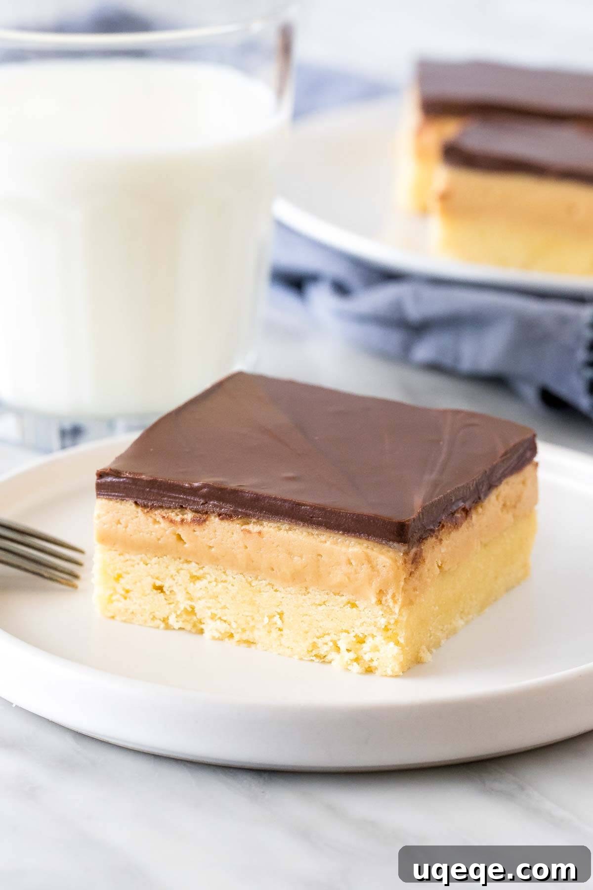 Peanut butter millionaire's shortbread bar on a plate with a glass of milk.