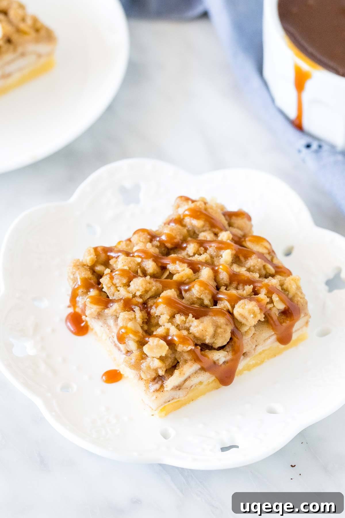 Homestyle Apple Crisp Bars 2 A perfectly sliced apple crumble bar on a white plate, topped with a luscious caramel drizzle, showcasing its distinct layers.