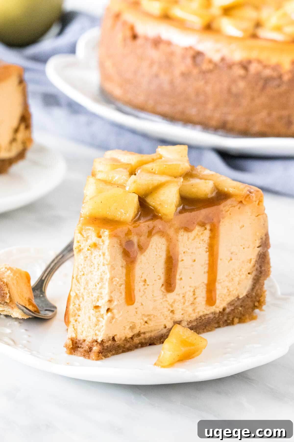 A slice of caramel cheesecake topped with cinnamon apples, with a bite taken out, showing the creamy texture.