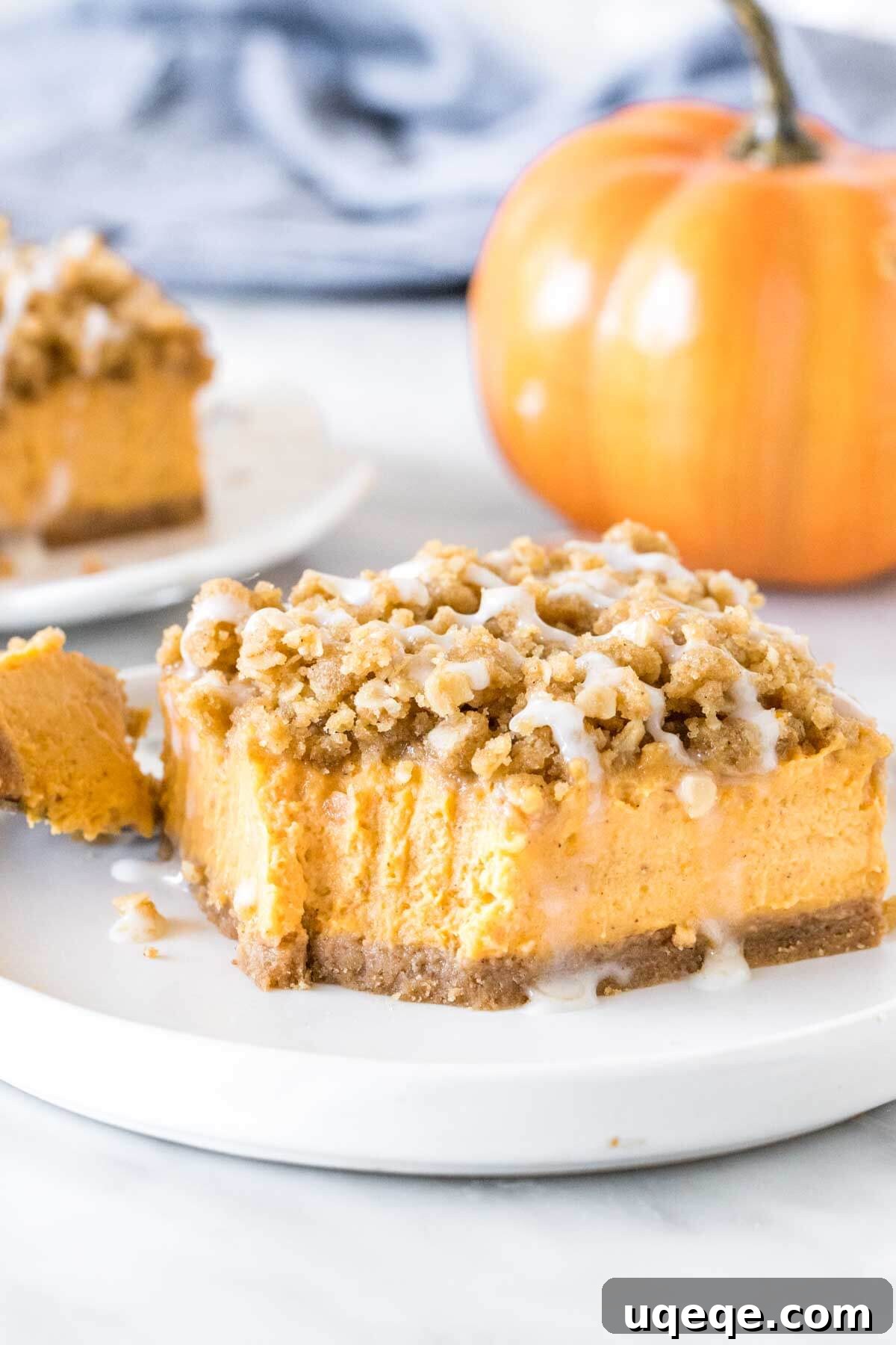 A perfectly portioned slice of pumpkin cheesecake bar, crowned with a hearty oatmeal topping, presented invitingly on a simple plate, ready to be savored.