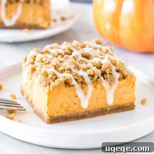 A square piece of pumpkin cheesecake streusel bars on a plate.