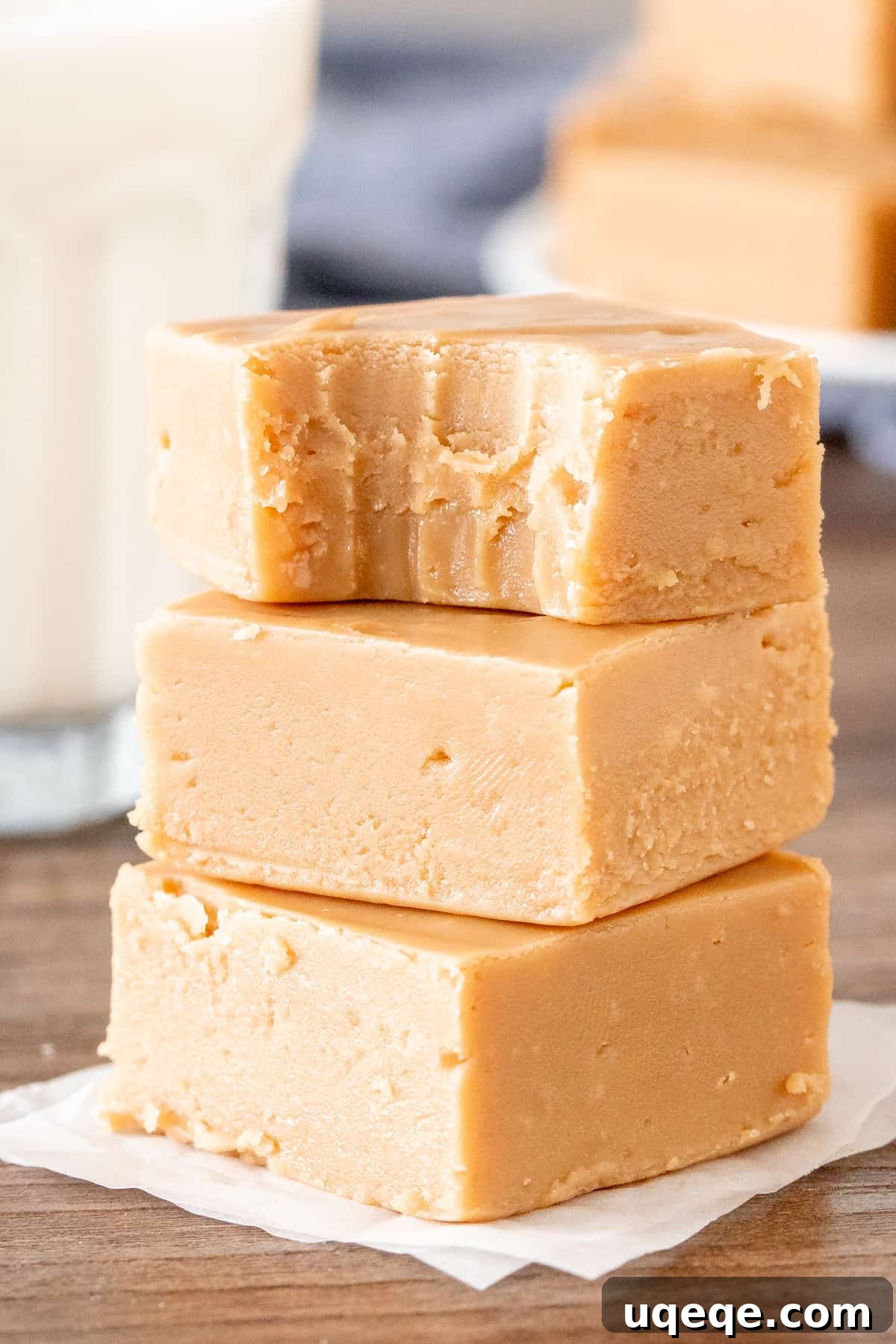 Effortless Condensed Milk Caramel Fudge 5 Three pieces of golden, creamy caramel fudge stacked on top of each other, showcasing their perfect square shape and smooth texture