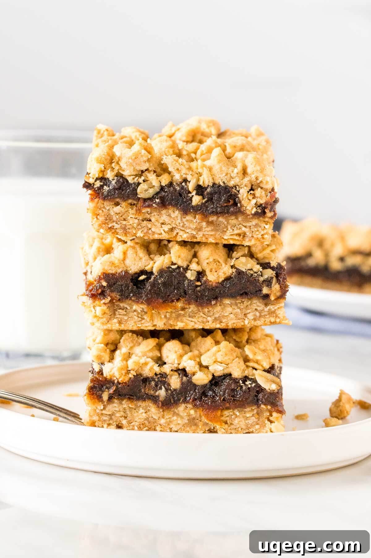 Golden Date Crumb Bars 5 Stack of three perfectly sliced date squares, showcasing the thick date filling and golden oatmeal crumble topping.