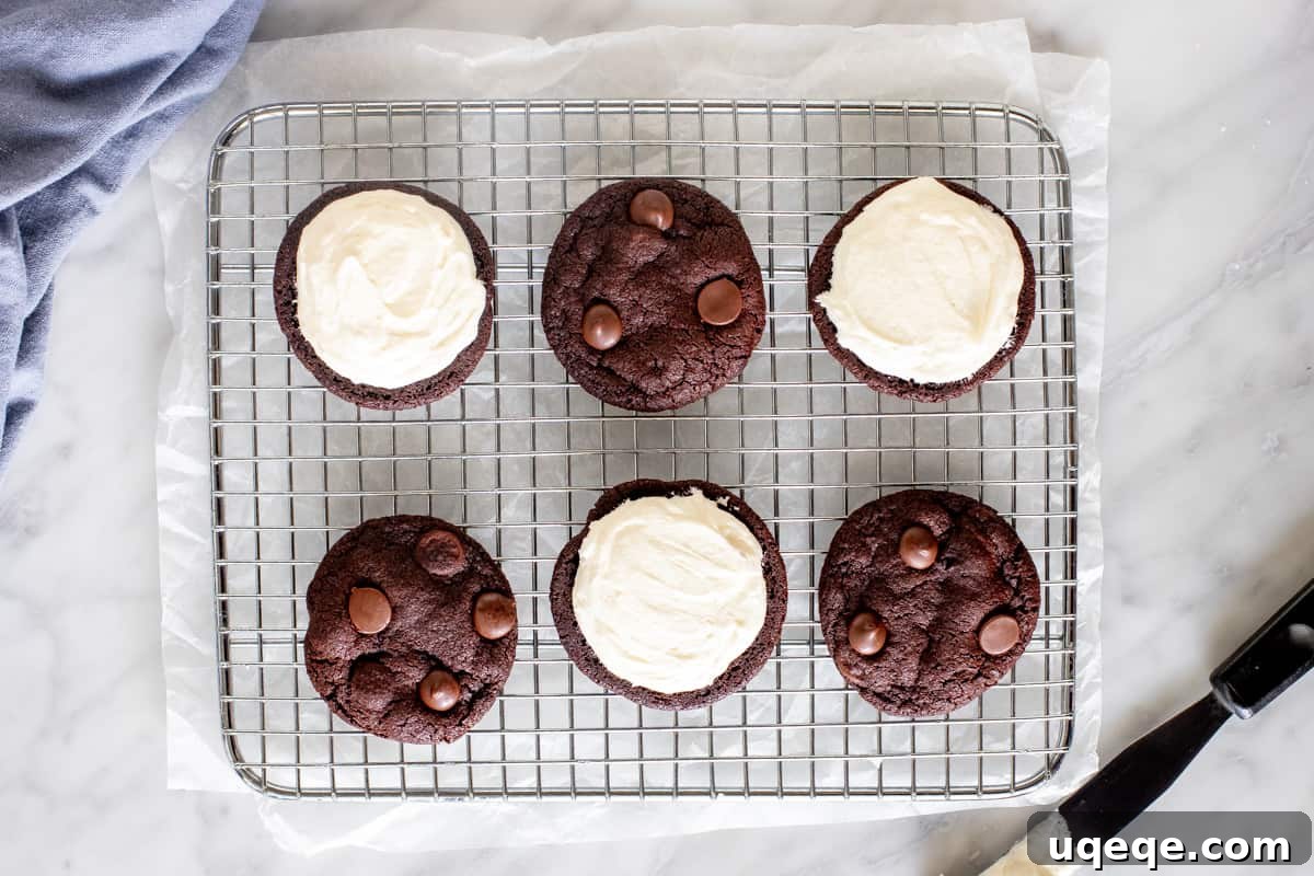 Decadent Chocolate Cremes 3 Chocolate cookies on a wire cooling rack with vanilla frosting.