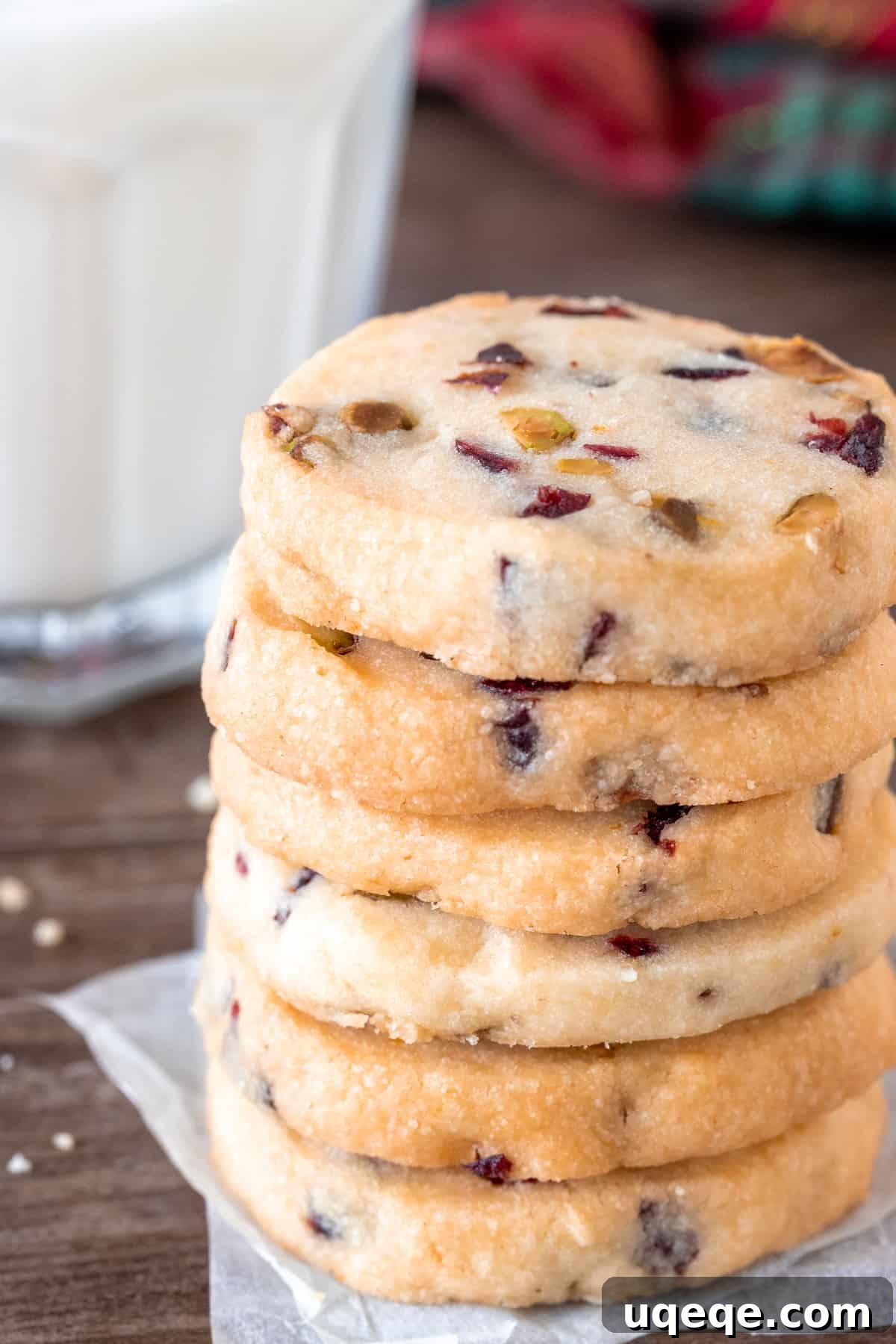 Jeweled Cranberry Pistachio Shortbread 3 A close-up shot of perfectly baked Cranberry Pistachio Shortbread cookies stacked on a plate, showcasing their inviting golden edges and colorful inclusions.