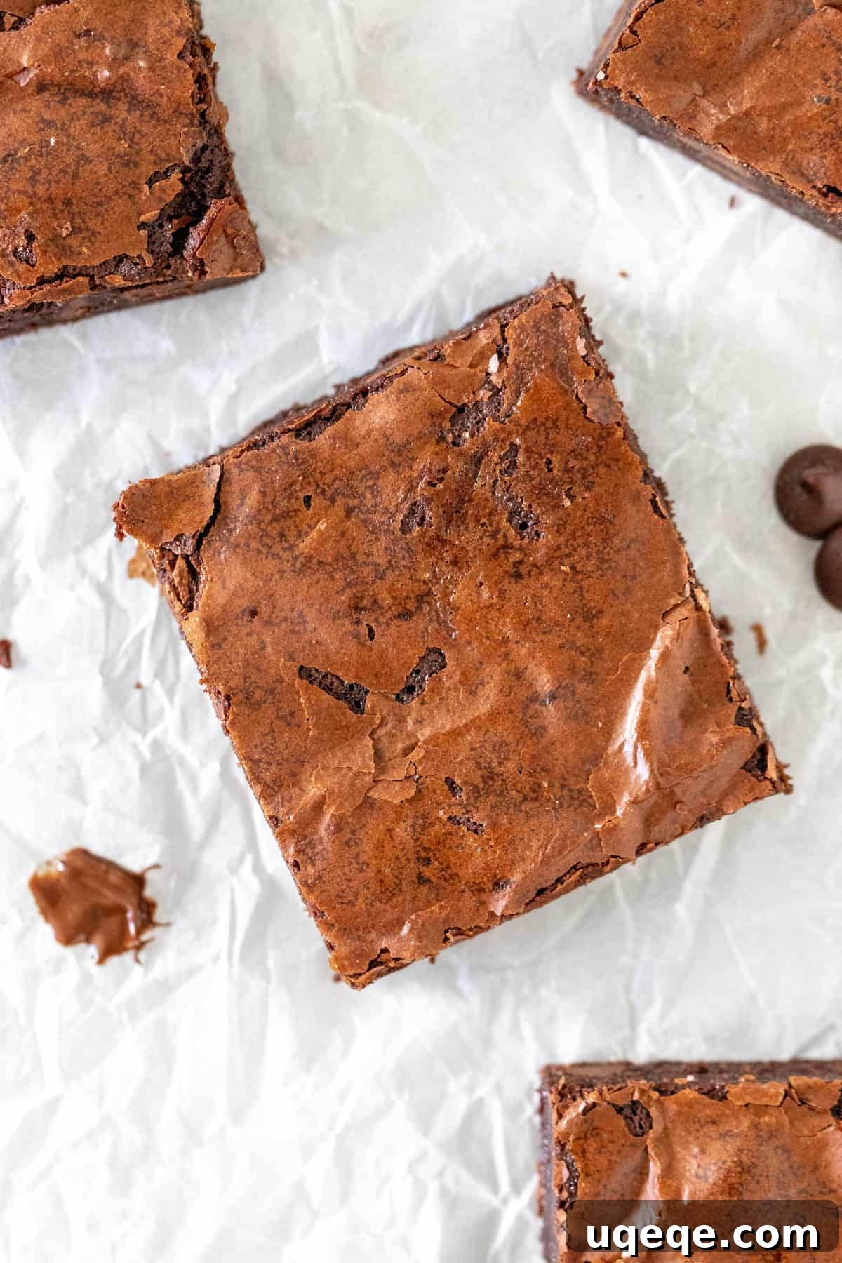 Fudgy Flourless Brownies 6 A single perfectly square, rich brownie resting on parchment paper.