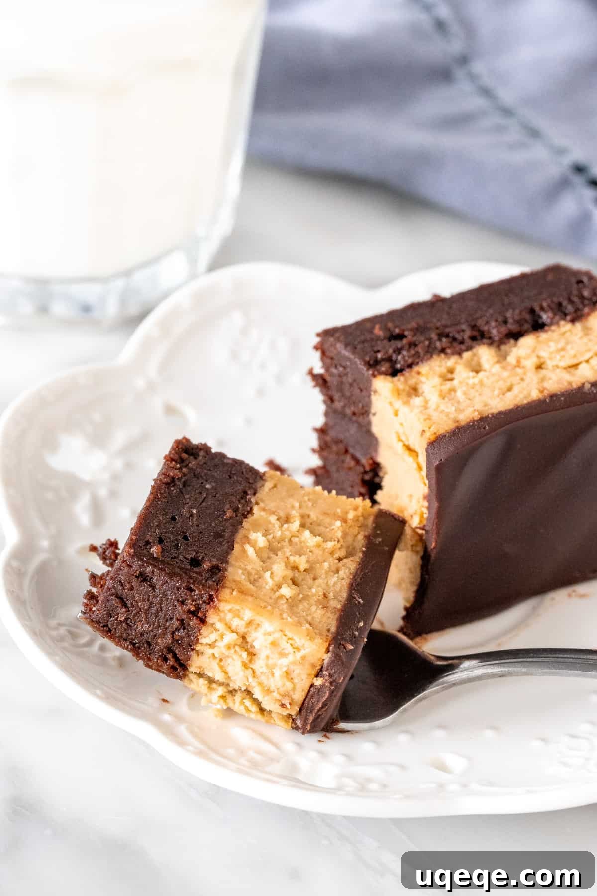 Ultimate Peanut Butter Cheesecake Brownies 4 A perfectly sliced bite of a peanut butter cheesecake brownie on a plate.