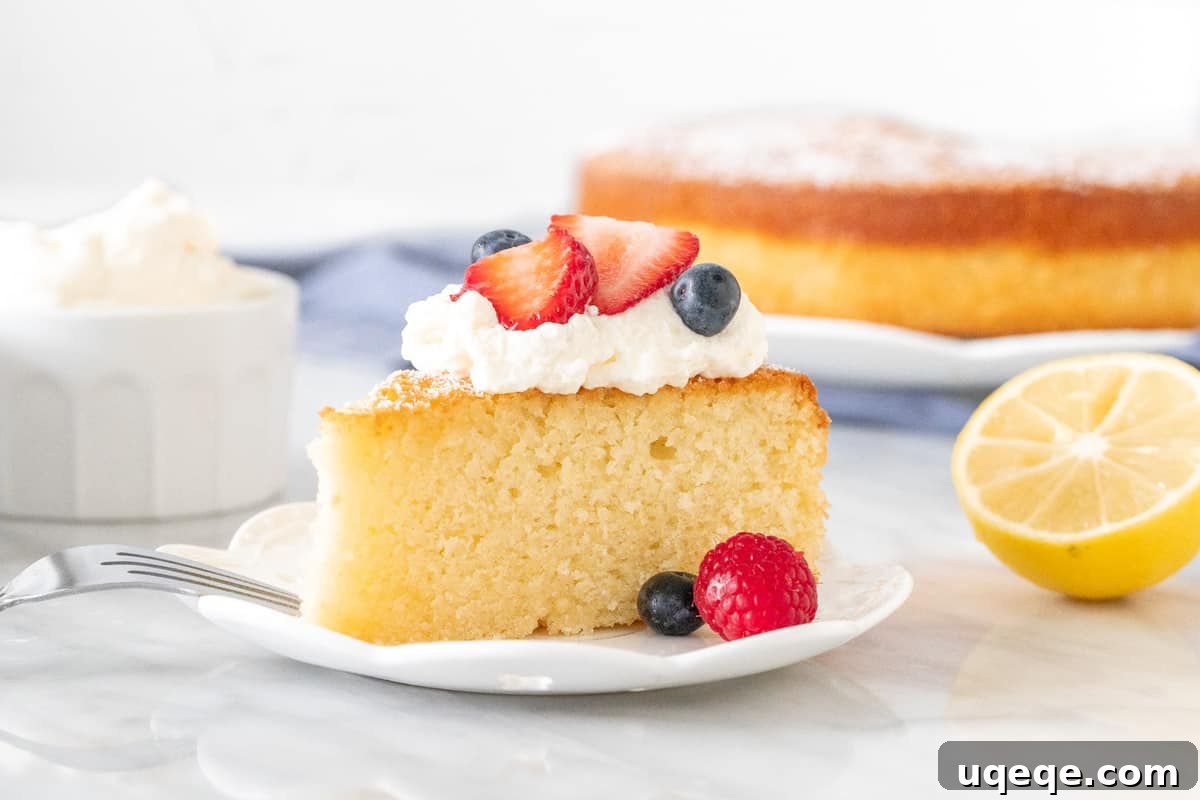 Sun-Kissed Lemon Olive Oil Cake 4 A plain slice of the moist lemon olive oil cake, awaiting creative toppings, next to a bowl of fresh berries and whipped cream.