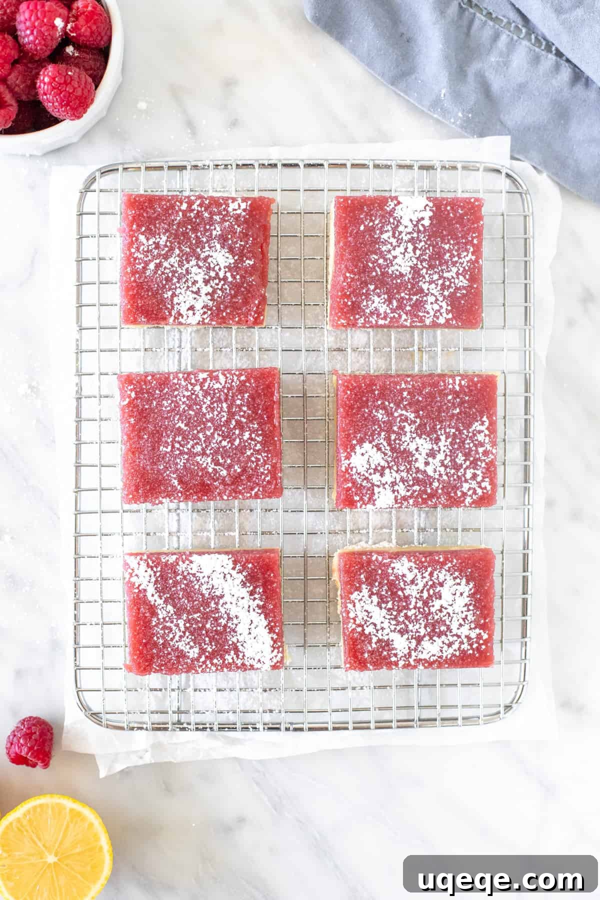 Sunshine Lemon Raspberry Bars 3 Six lemon raspberry bars, dusted with powdered sugar, cooling on a wire rack.