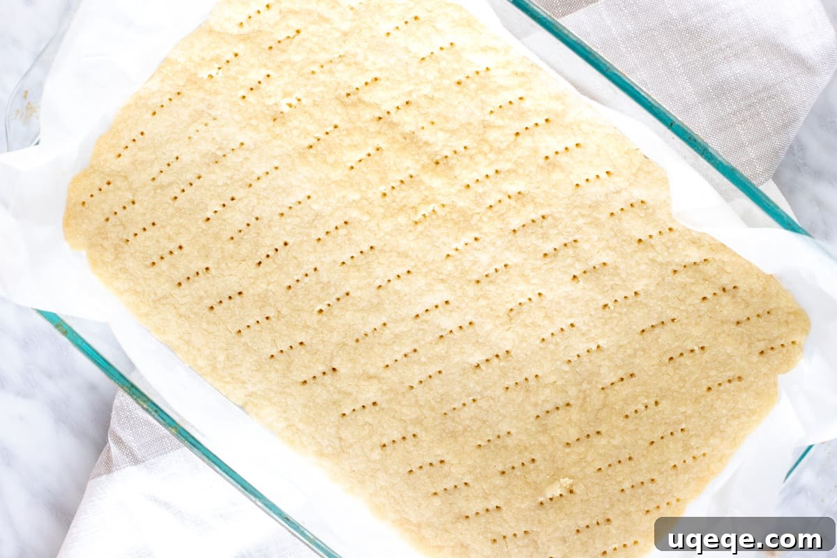 Sunshine Lemon Raspberry Bars 4 Close-up of a golden-brown shortbread base, ready for the lemon raspberry filling.