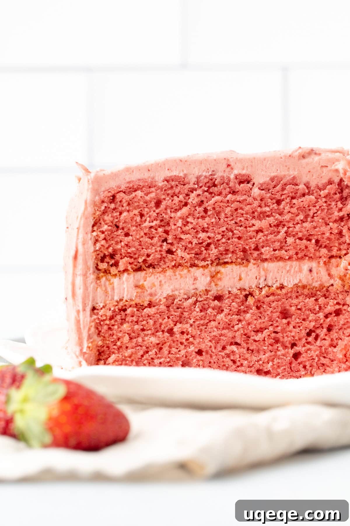Sweet Strawberry Dream Cake 3 A two-layer homemade strawberry cake with creamy strawberry frosting, beautifully sliced to reveal its moist, pink interior, emphasizing fresh strawberry flavor.
