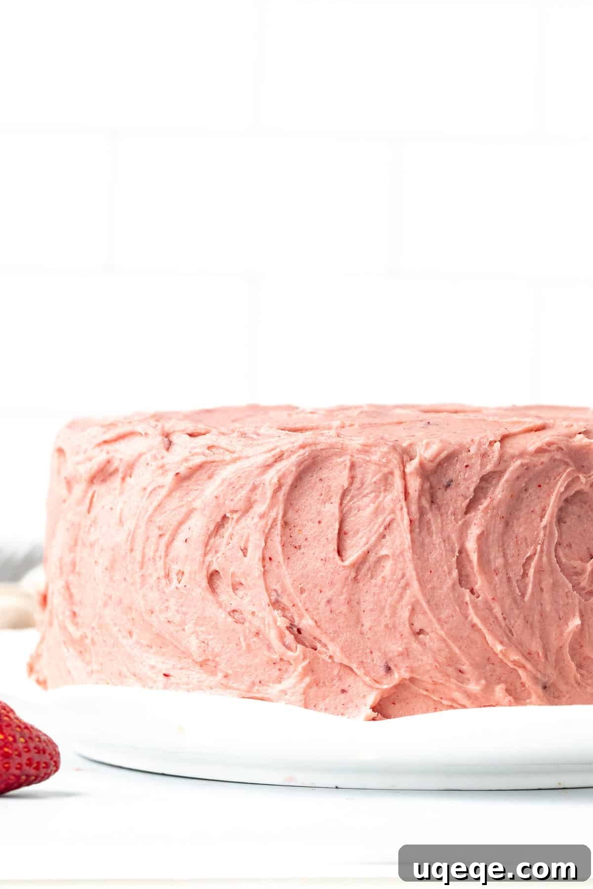 Sweet Strawberry Dream Cake 9 A beautifully decorated 8-inch round strawberry cake, generously frosted with swirls of pink strawberry buttercream, ready to be served.