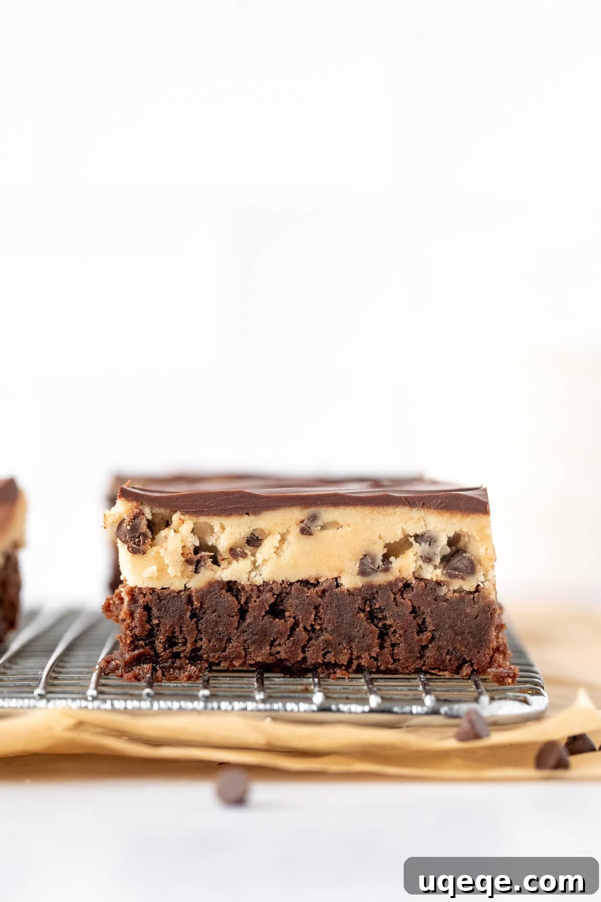Ultimate Cookie Brownie Bars 4 A cooling rack displaying a full pan of Cookie Dough Brownies, with distinct layers of fudgy brownie, edible cookie dough, and glossy chocolate topping.