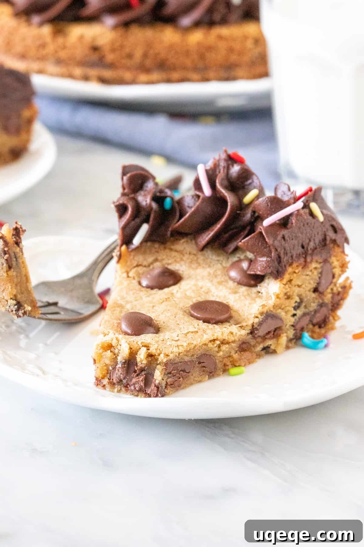 Ultimate Chocolate Chip Cookie Cake 6 A tempting slice of chocolate chip cookie cake with a bite taken out, showing its tender crumb and gooey chocolate.