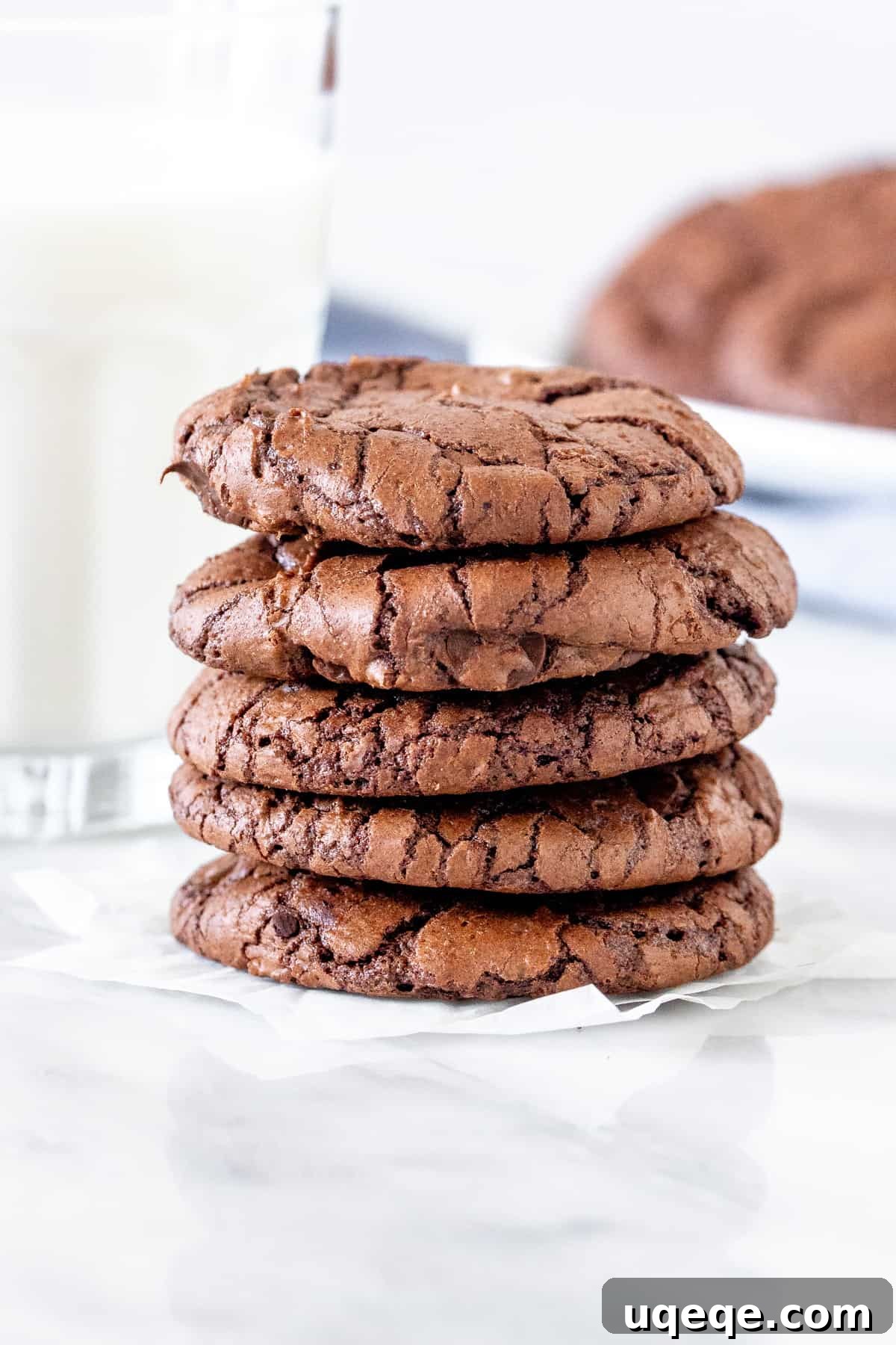 Gourmet Brownie Cookies 7 A perfectly stacked pile of five fudgy brownie cookies, showcasing their inviting crinkled tops and decadent appearance.