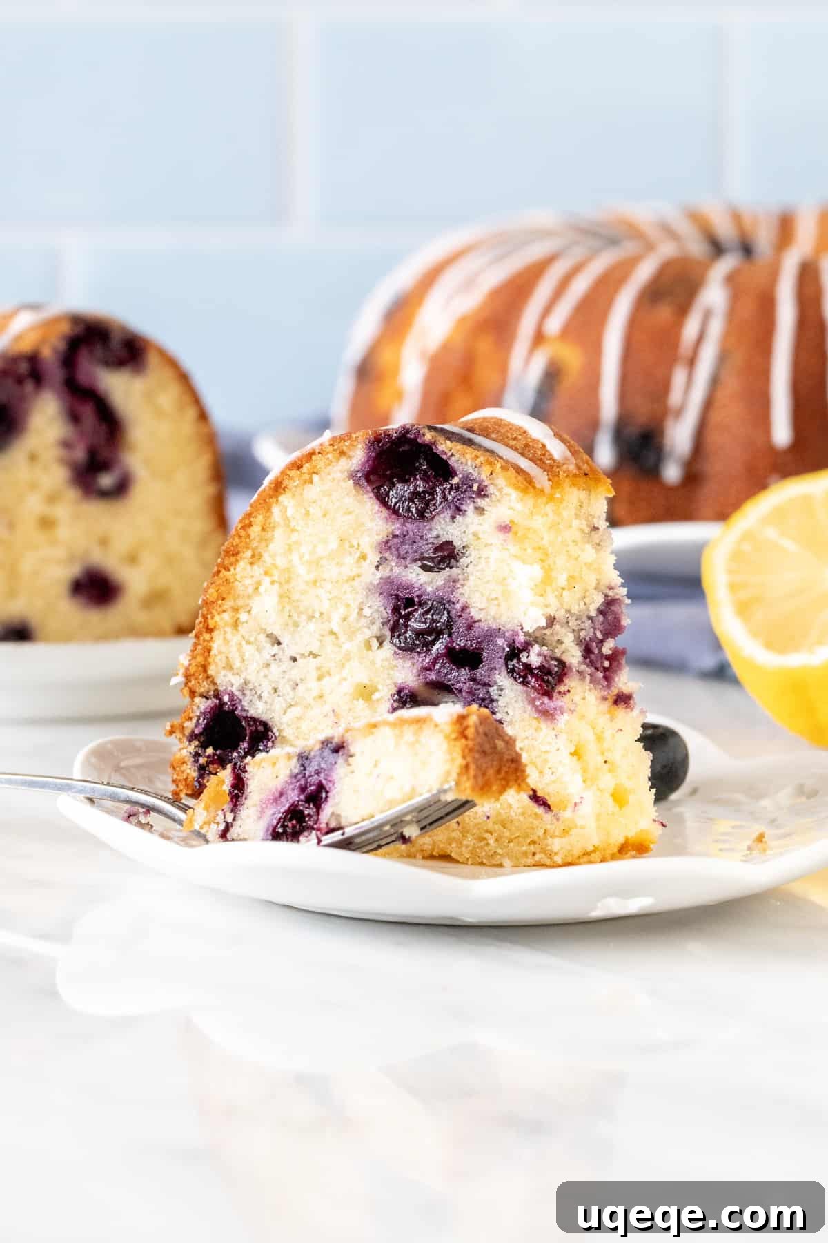 Sunshine Lemon Blueberry Bundt 4 Slice of lemon blueberry bundt cake, with bite taken out.